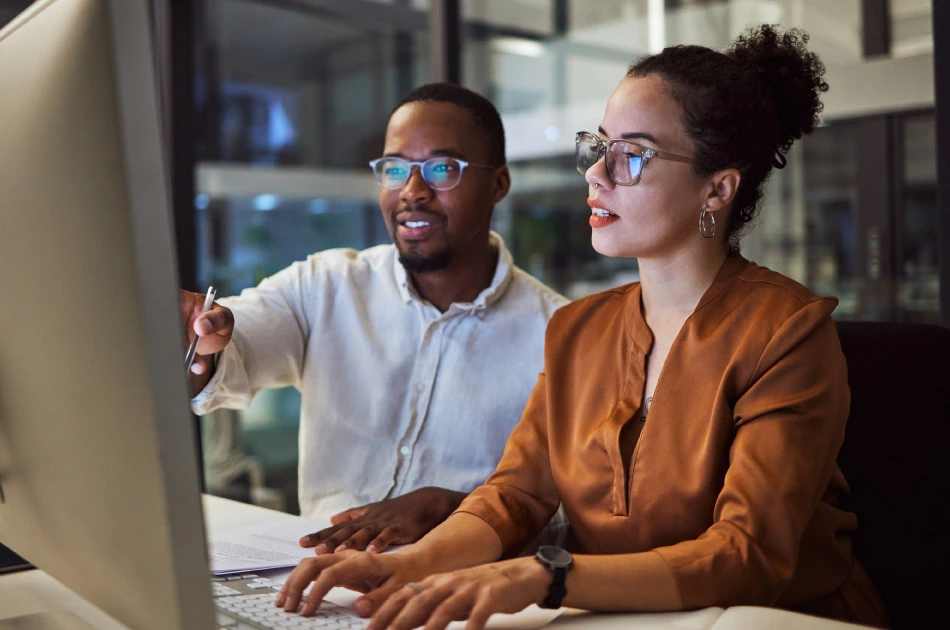 Corporate African man and woman talking about business collaboration during overtime together Corporate African man and woman talking about business collaboration during overtime together