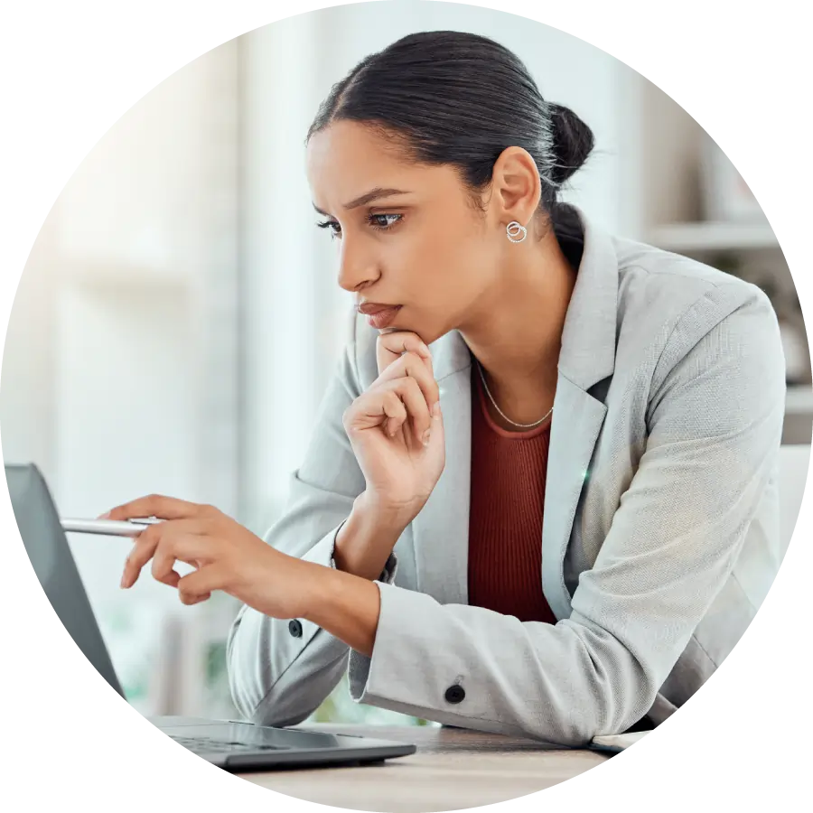 Serious professional businesswoman sitting and reading a work email with a pen working from home
